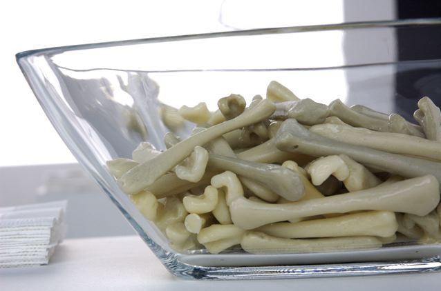 A glass bowl filled with candy made to look like human bones.