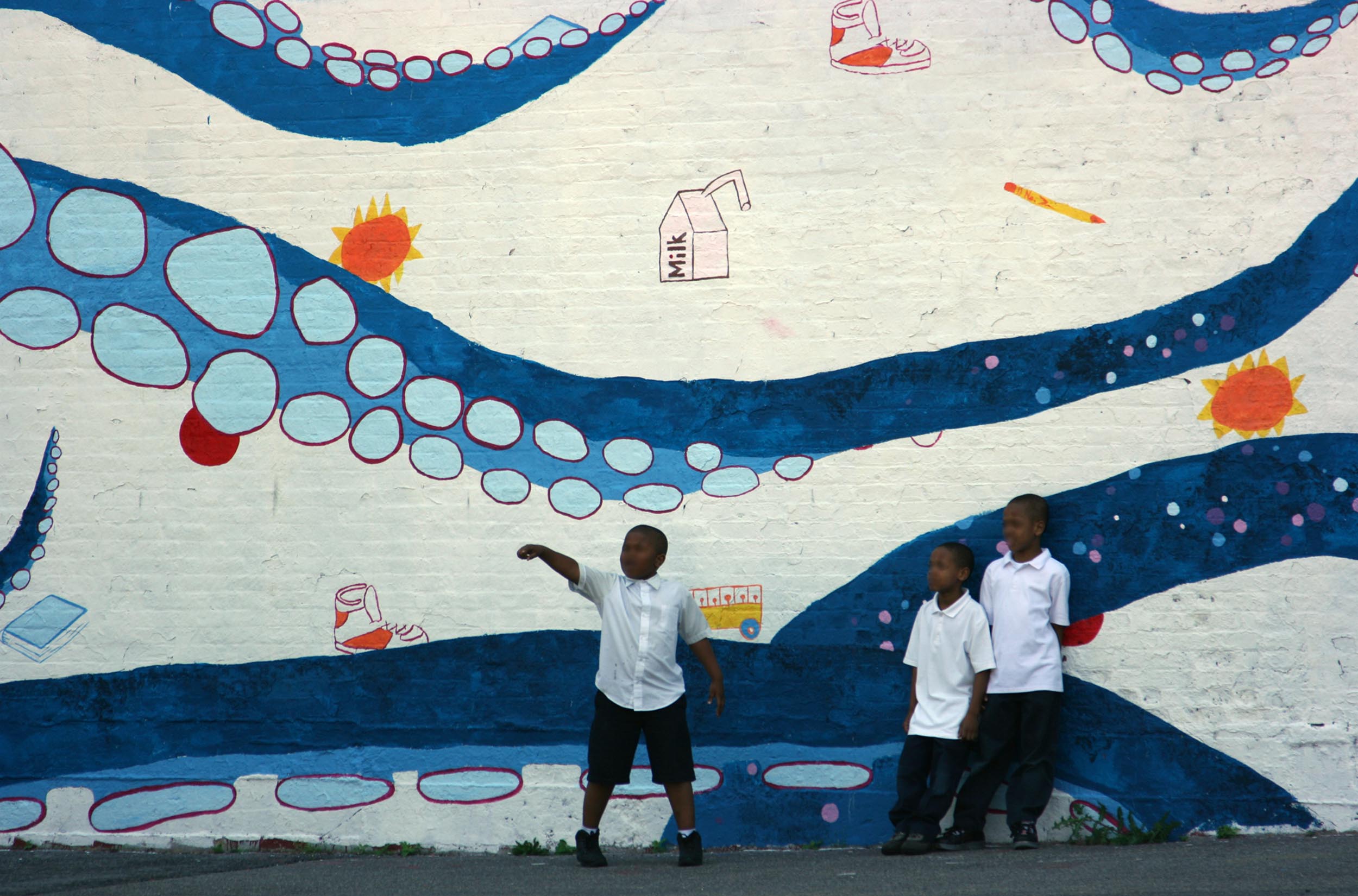 Mural detail with kids standing in front of octopus tentacles.